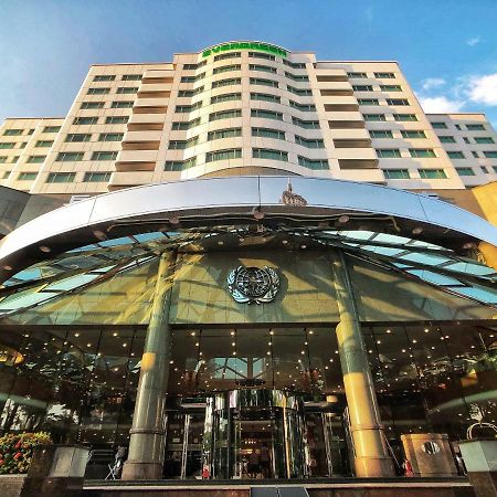 فندق إيفرجرين لوريل، تايتشونج تايتشونغ المظهر الخارجي الصورة The photo shows the exterior of a modern hotel building. The entrance features a large, glass canopy supported by columns, creating a welcoming area. The facade of the hotel is composed of a mix of glass and concrete, with large windows that suggest 