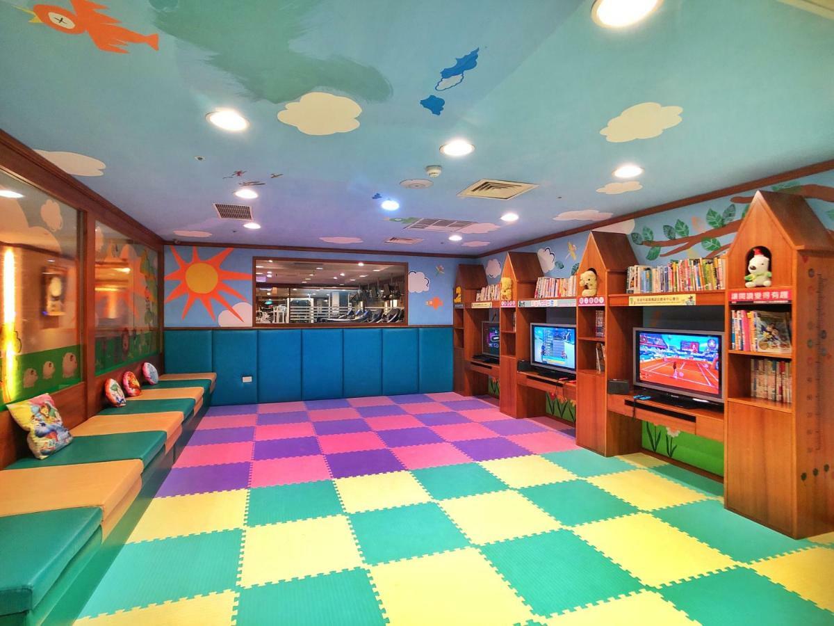 فندق إيفرجرين لوريل، تايتشونج تايتشونغ المظهر الخارجي الصورة The photo shows a brightly colored children's playroom or activity area. The floor is covered with large colorful tiles in shades of blue, green, yellow, and pink, creating a playful pattern. The walls have cheerful decorations, including sun and clo