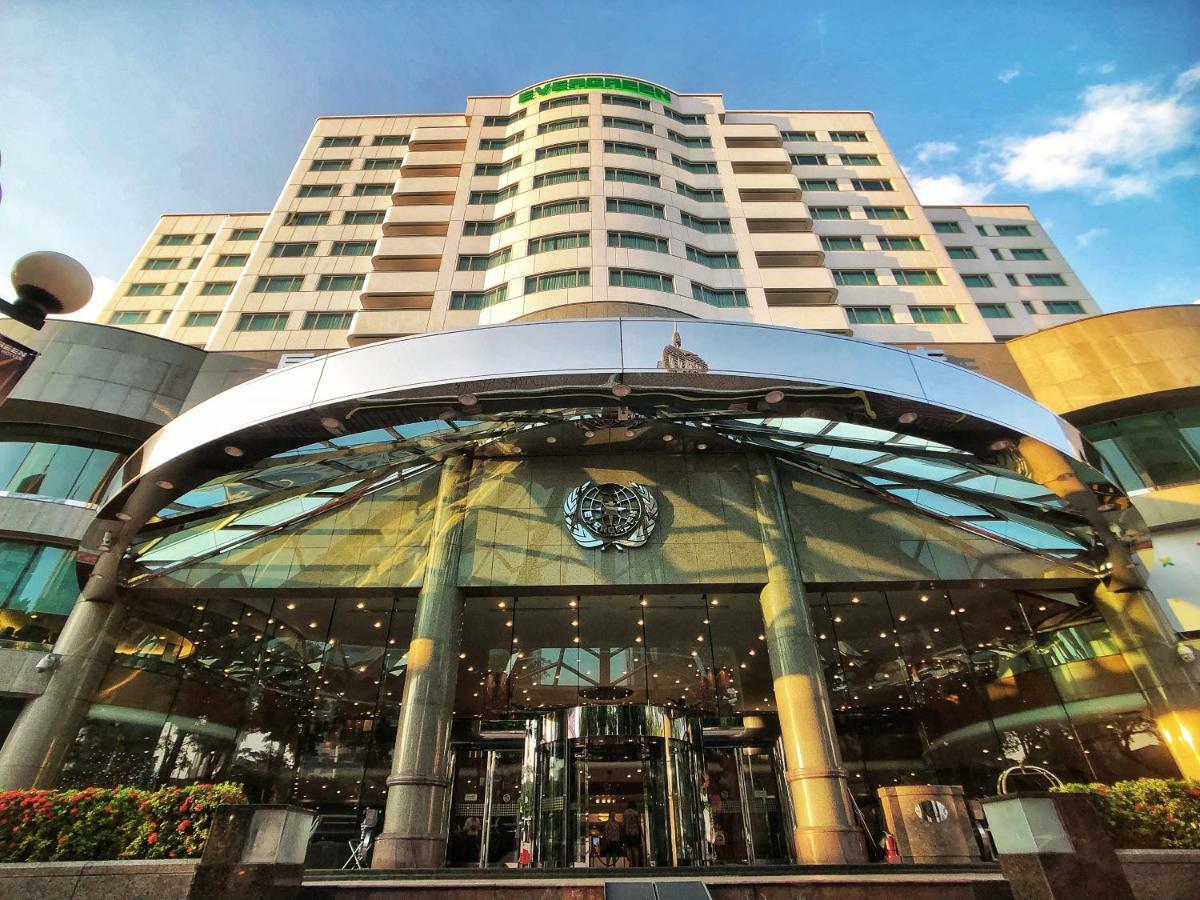 فندق إيفرجرين لوريل، تايتشونج تايتشونغ المظهر الخارجي الصورة The photo shows the exterior of a modern hotel building. The entrance features a large, glass canopy supported by columns, creating a welcoming area. The facade of the hotel is composed of a mix of glass and concrete, with large windows that suggest 