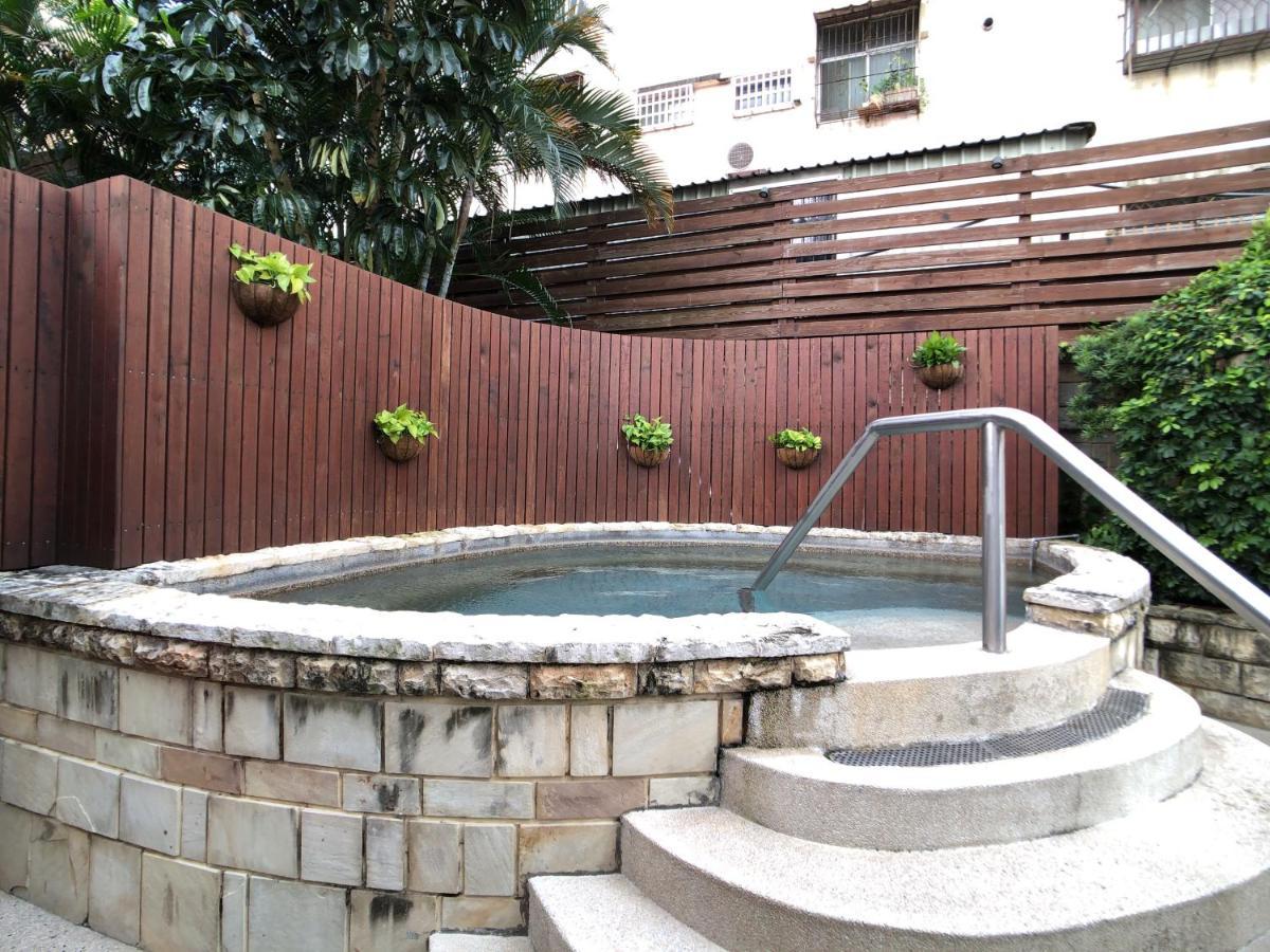 فندق إيفرجرين لوريل، تايتشونج تايتشونغ المظهر الخارجي الصورة The photo shows a small outdoor hot tub or spa area. It's surrounded by a wooden fence, with several planters containing greenery attached to the wall. The hot tub is round, with a stone border, and there are steps leading up to it with a stainless s